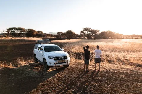 Clients stopping at sunset next to their Namib Trails 4x4 in the Namibian bush