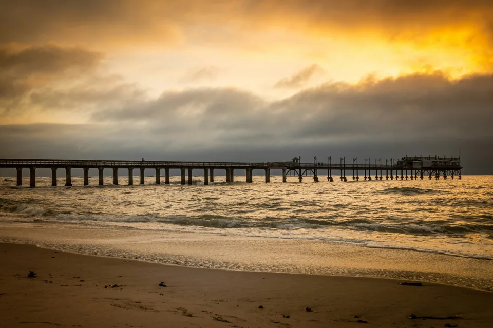 Swakopmund pier stretching into the Atlantic Ocean at golden sunset